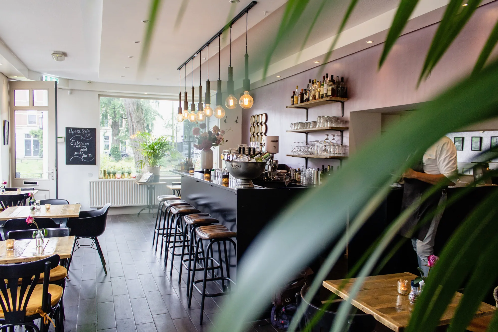 Bar de hostelería con barra y mesas